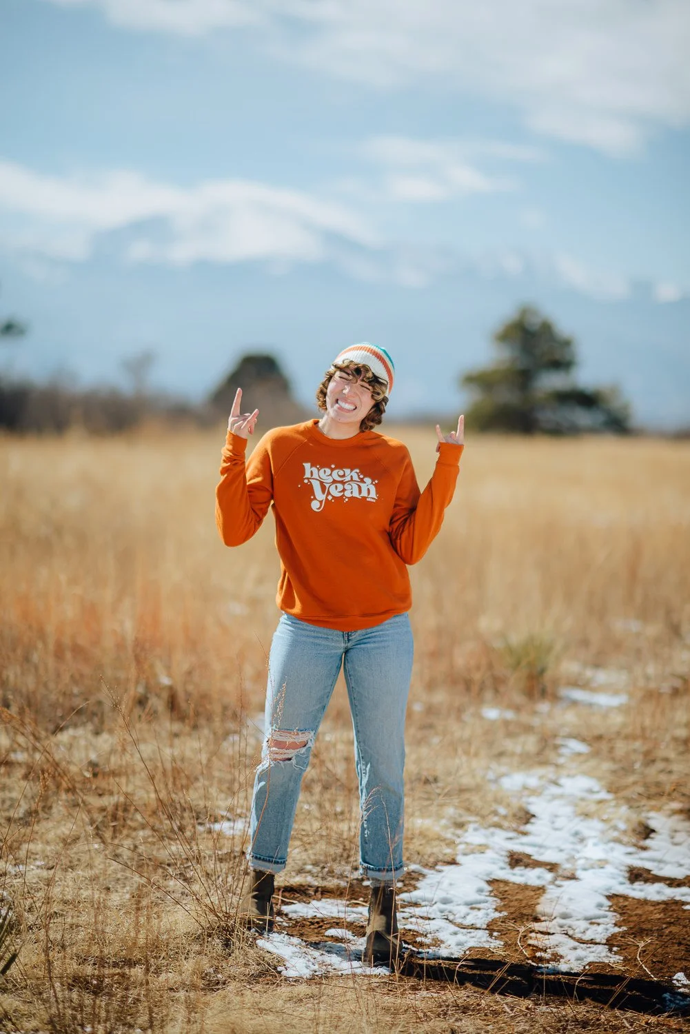 Lifestyle photography of a model wearing an orange crewneck sweater at Palmer Park in Colorado Springs, Colorado for Akinz Boardwear