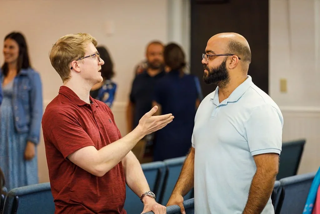 two men speaking to each other at grace bible church of tampa