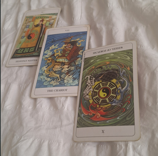 Three Chinese tarot cards on a white background.
