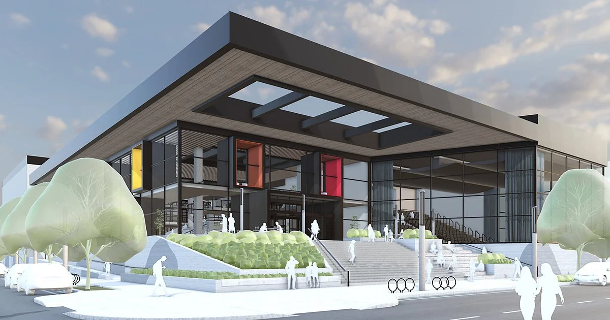 Vue d'un bâtiment moderne avec une façade en verre, des escaliers et des arbres autour, vu lors du crépuscule.