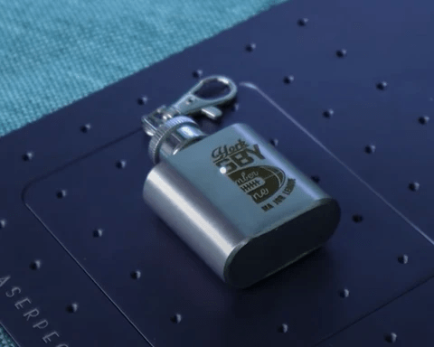 Cadenas de calibre, clé et une serrure en acier posés sur une surface noire perforée.