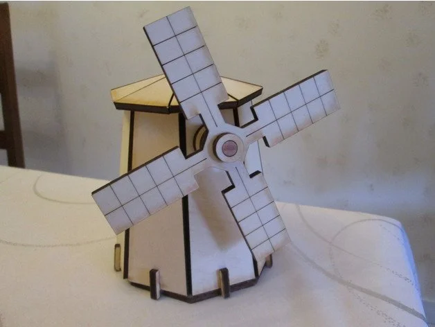 Modèle réduit d'un moulin à vent en bois avec quatre pâles, placé sur une table