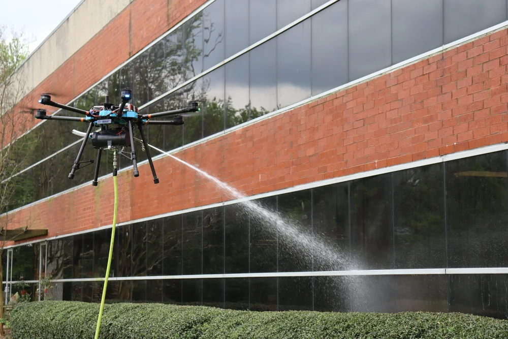Drone pulvérisant une façade de bâtiment