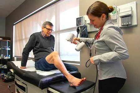 Un médecin examine le genou d'un patient dans un cabinet médical.