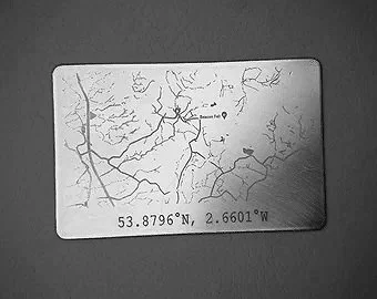 Carte en plastique avec coordonnées géographiques 53.8796°N, 2.6601°W et dessin de branches d'arbres
