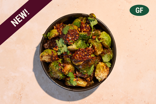 Chili Garlic Brussels Sprouts topped with chili garlic crisp, lime juice, and cilantro.