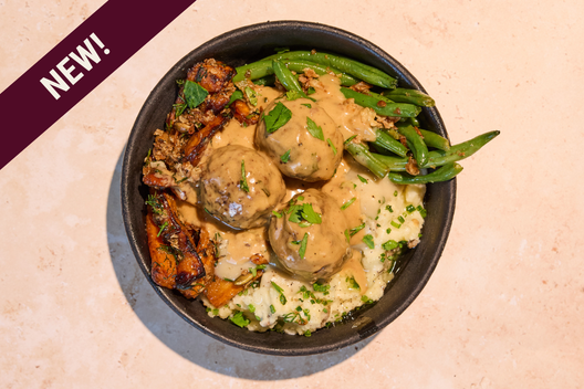 Meatballs & Mash Plate with 100% Grass-fed Meatballs topped with Gravy and paired with Creamy mashed potatoes, green beans, and maple glazed carrots.