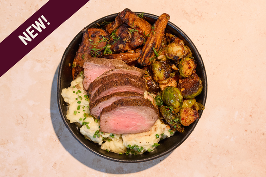 Steak & Mash Plate with Grass-fed, grain-finished Steak, chili garlic brussels sprouts, maple glazed carrots, creamy mashed potatoes, and gravy.