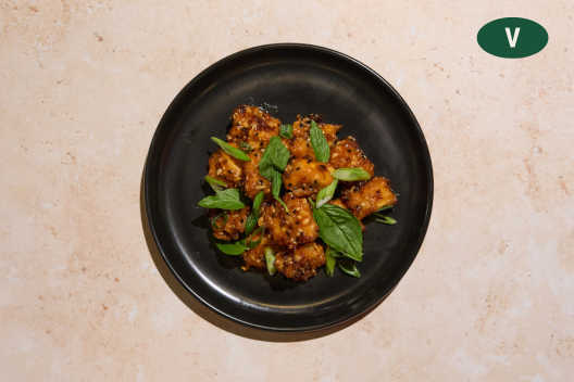 Crispy Sesame Tofu topped with basil and green onion.Crispy sesame tofu topped with basil and green onion.