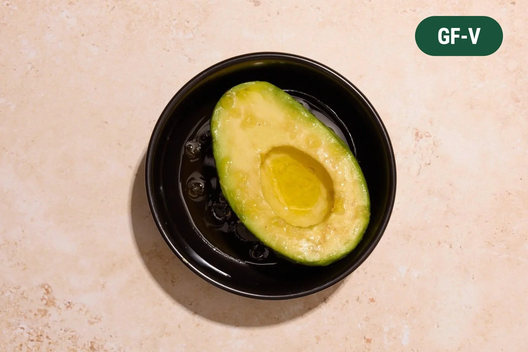Half of an avocado with a drizzle of extra virgin olive oil and sea salt.
