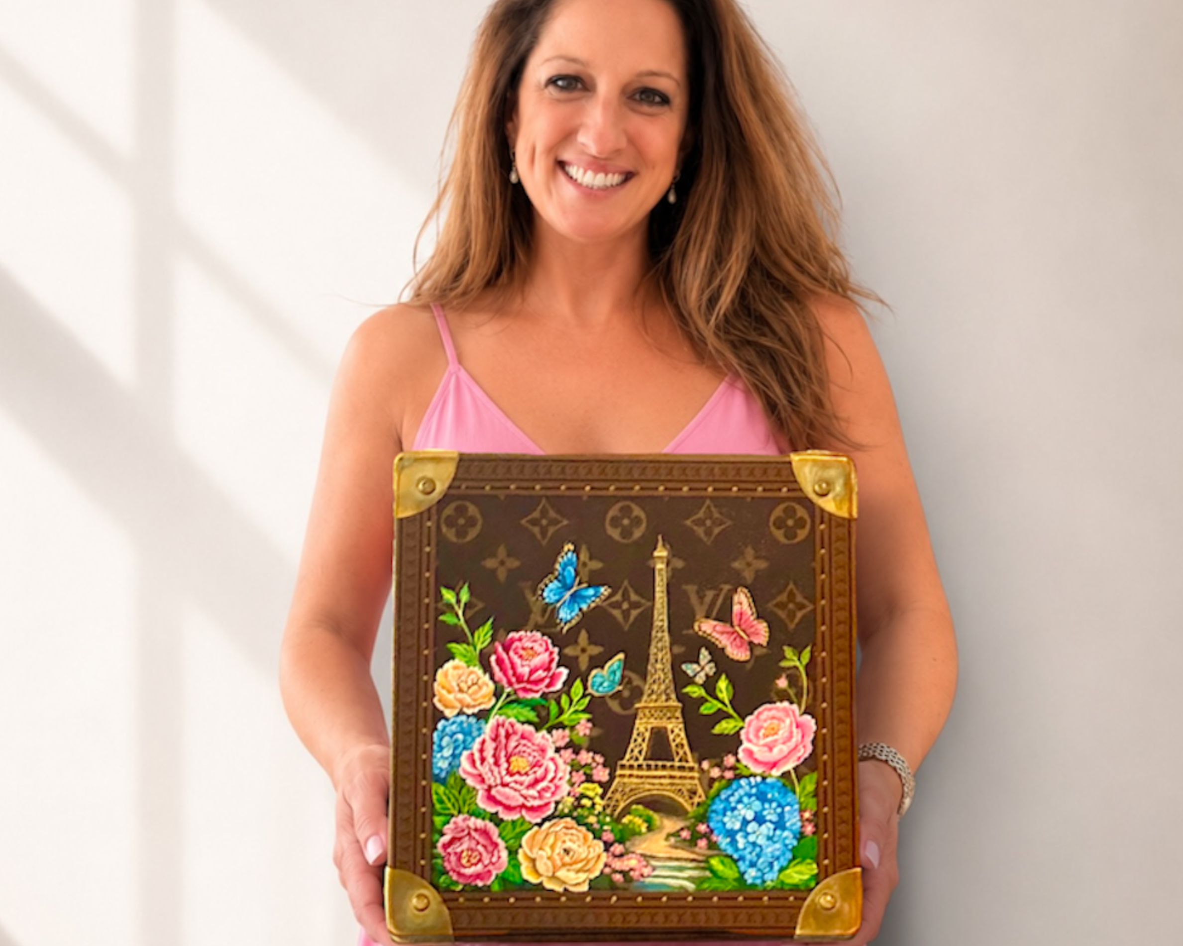 Michele holding a Louis Vuitton trunk she restored and painted for a private client.