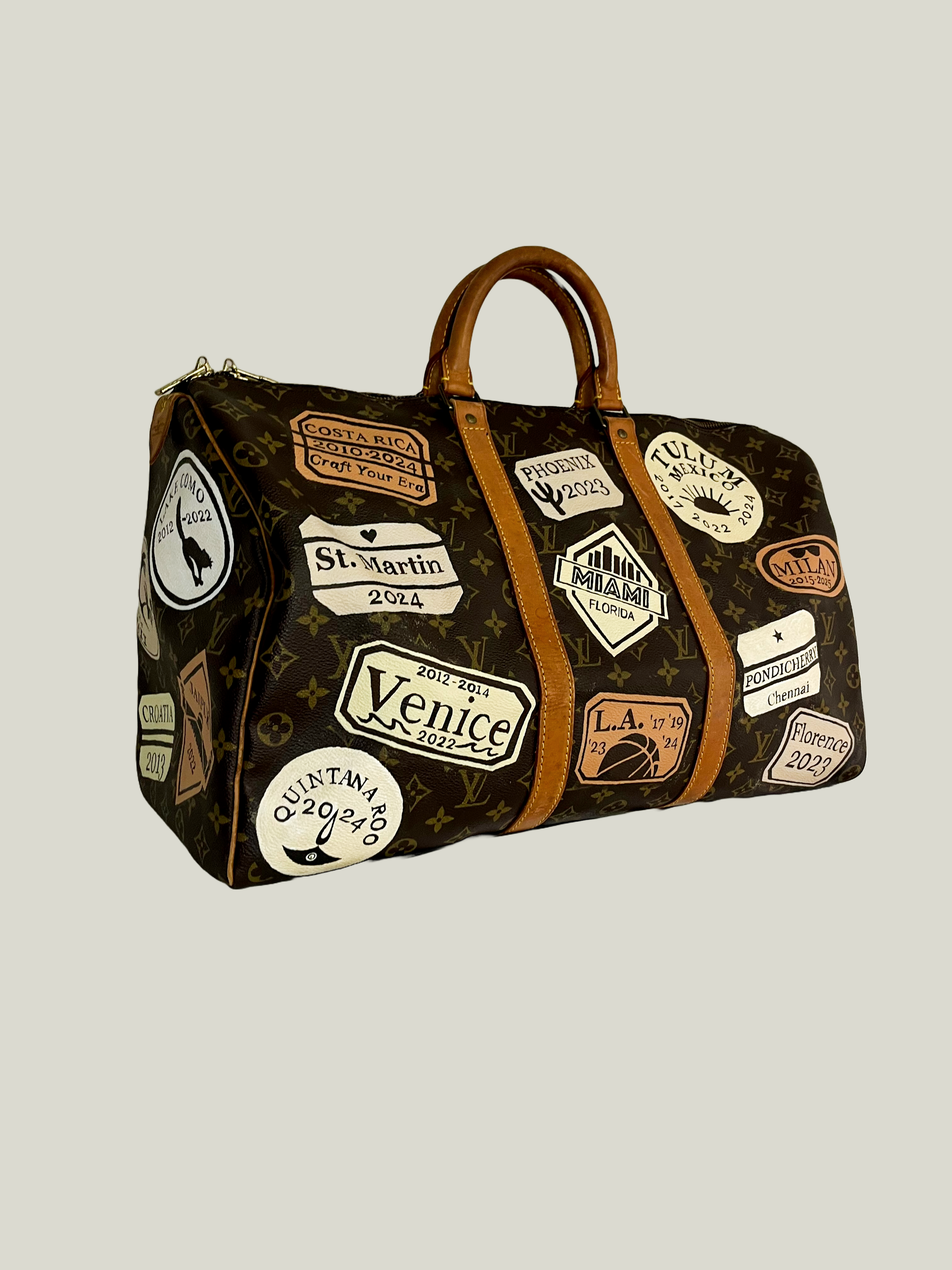 Custom painted travel stamps from all her family's favorite destinations designed and handpainted on 4 sides of this duffel by Michele Sobel Fine Art