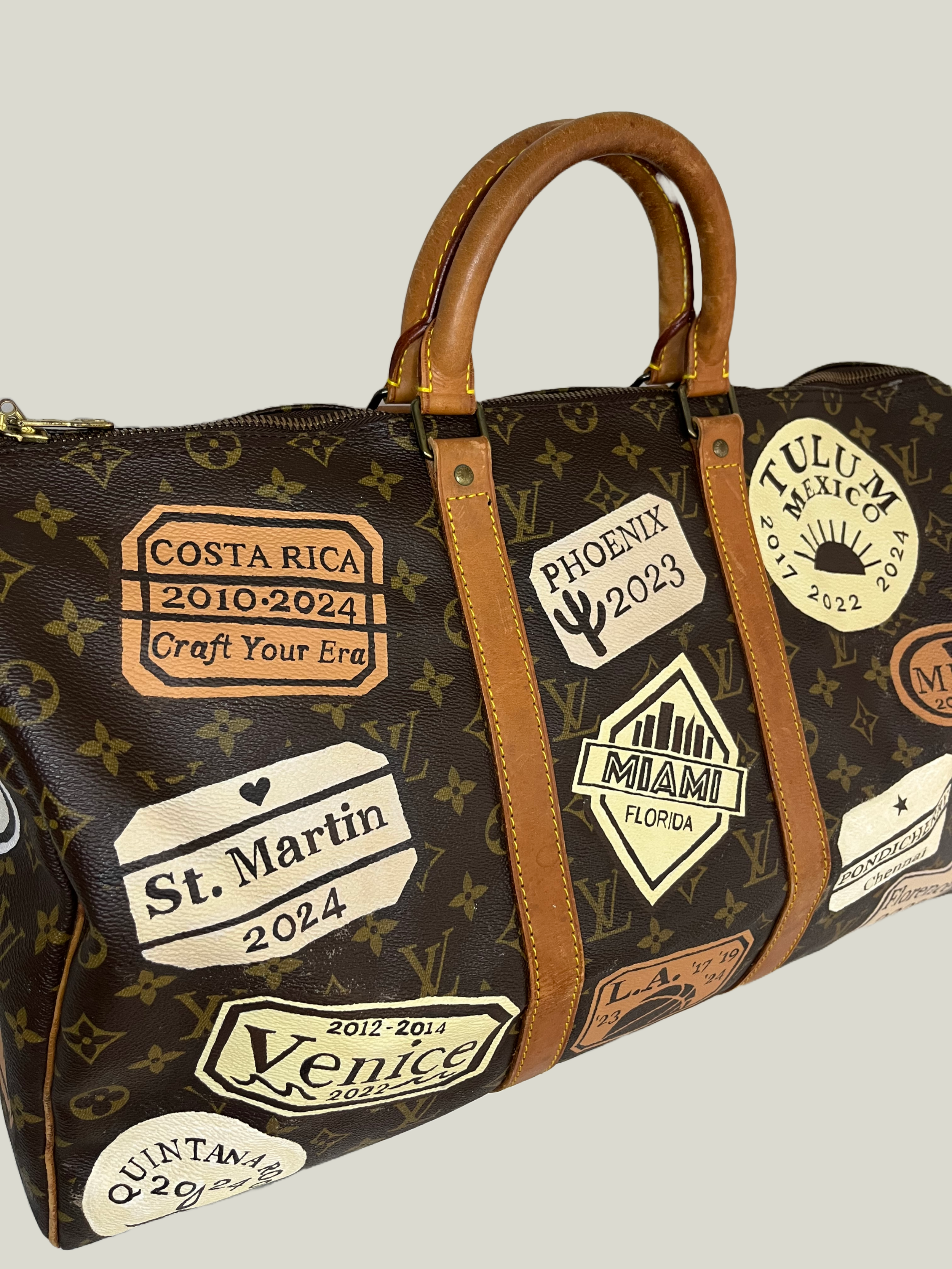 Custom painted travel stamps from all her family's favorite destinations designed and handpainted on 4 sides of this duffel by Michele Sobel Fine Art