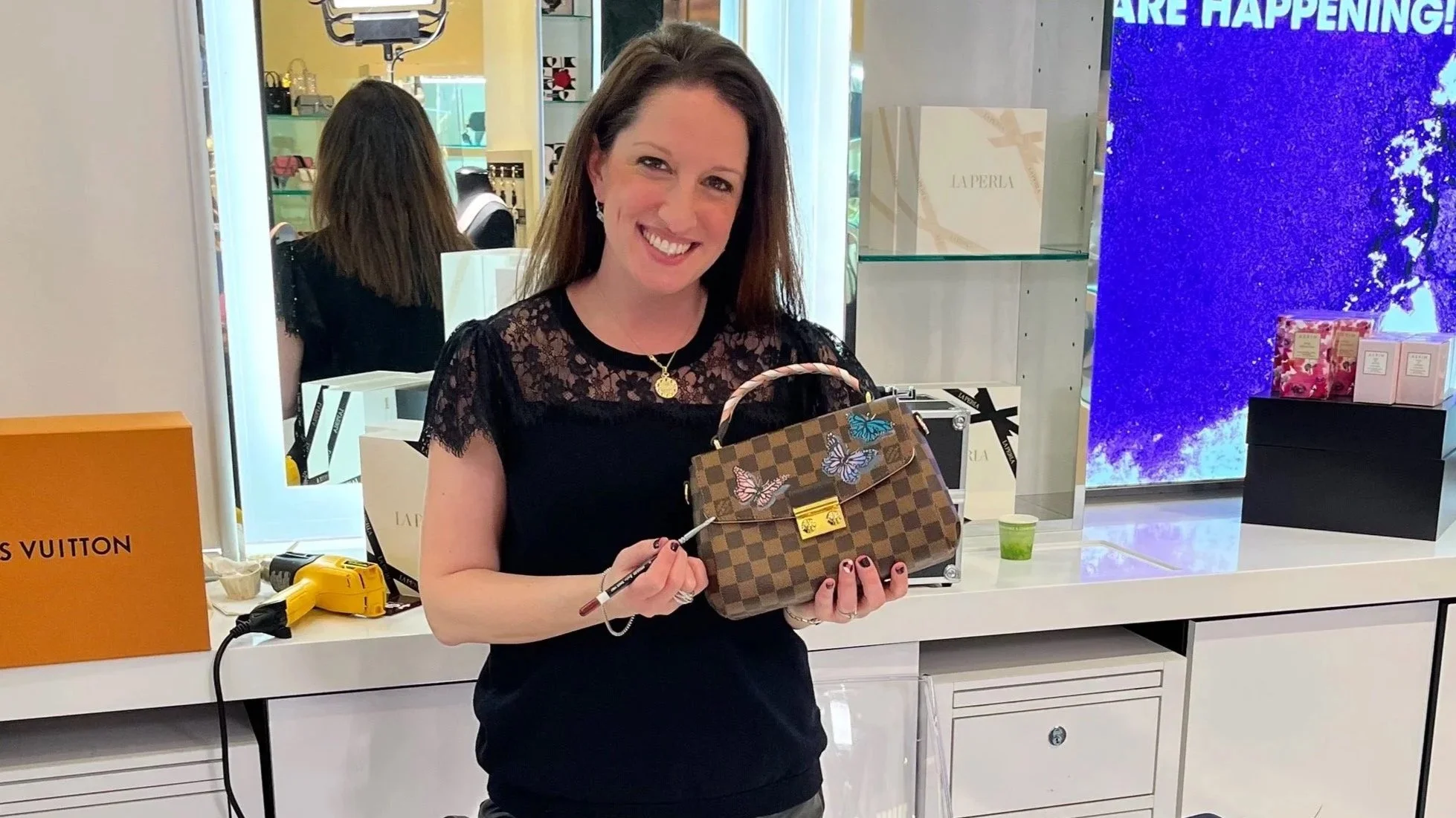 Hand Painting a Louis Vuitton Bag with butterflies for a client at Bloomingdales 59th Street.