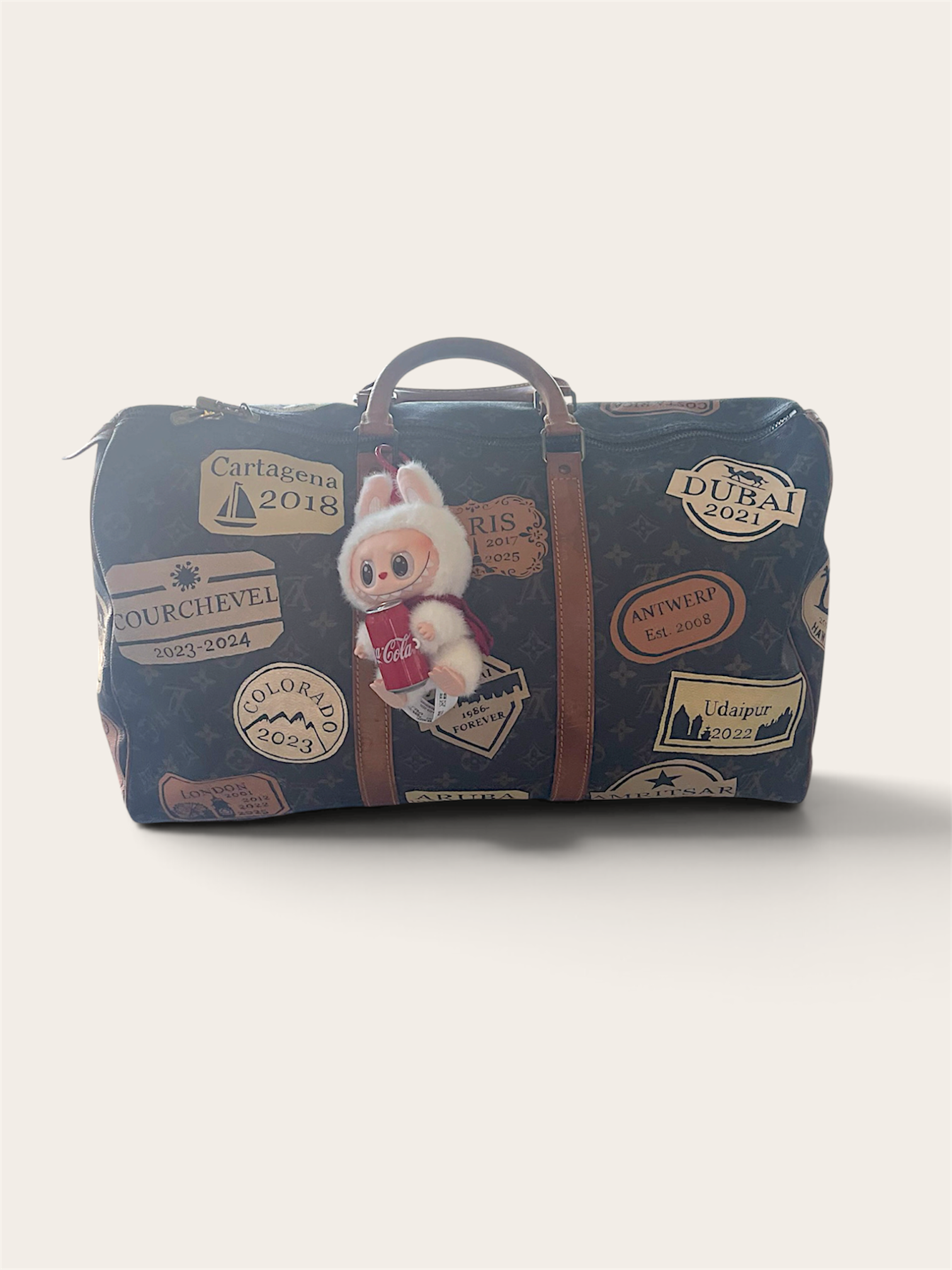 Custom painted travel stamps from all her family's favorite destinations designed and handpainted on 4 sides of this duffel by Michele Sobel Fine Art