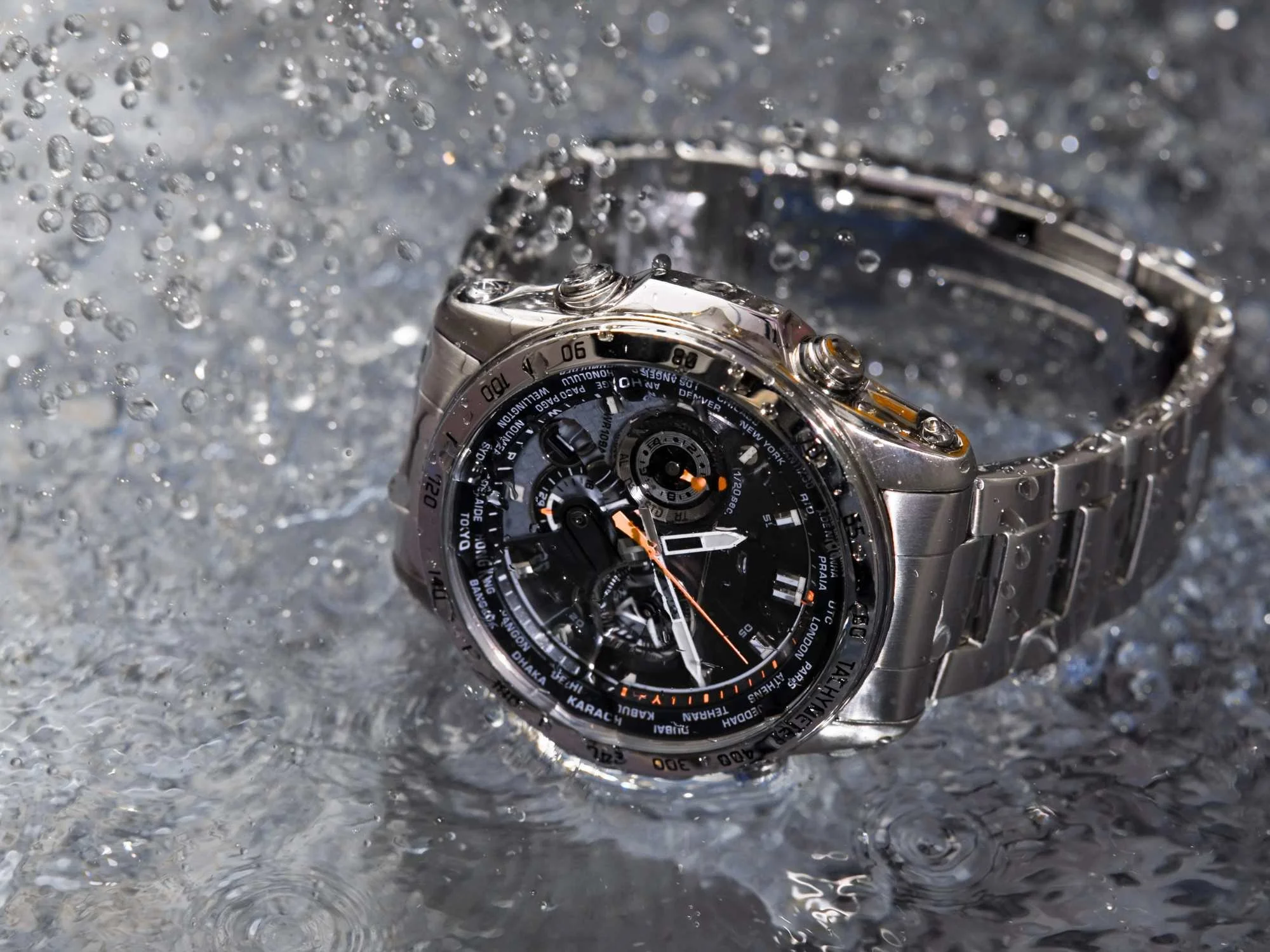 Stainless steel wristwatch surrounded by splashing water, illustrating watch water resistance and protection against everyday moisture.