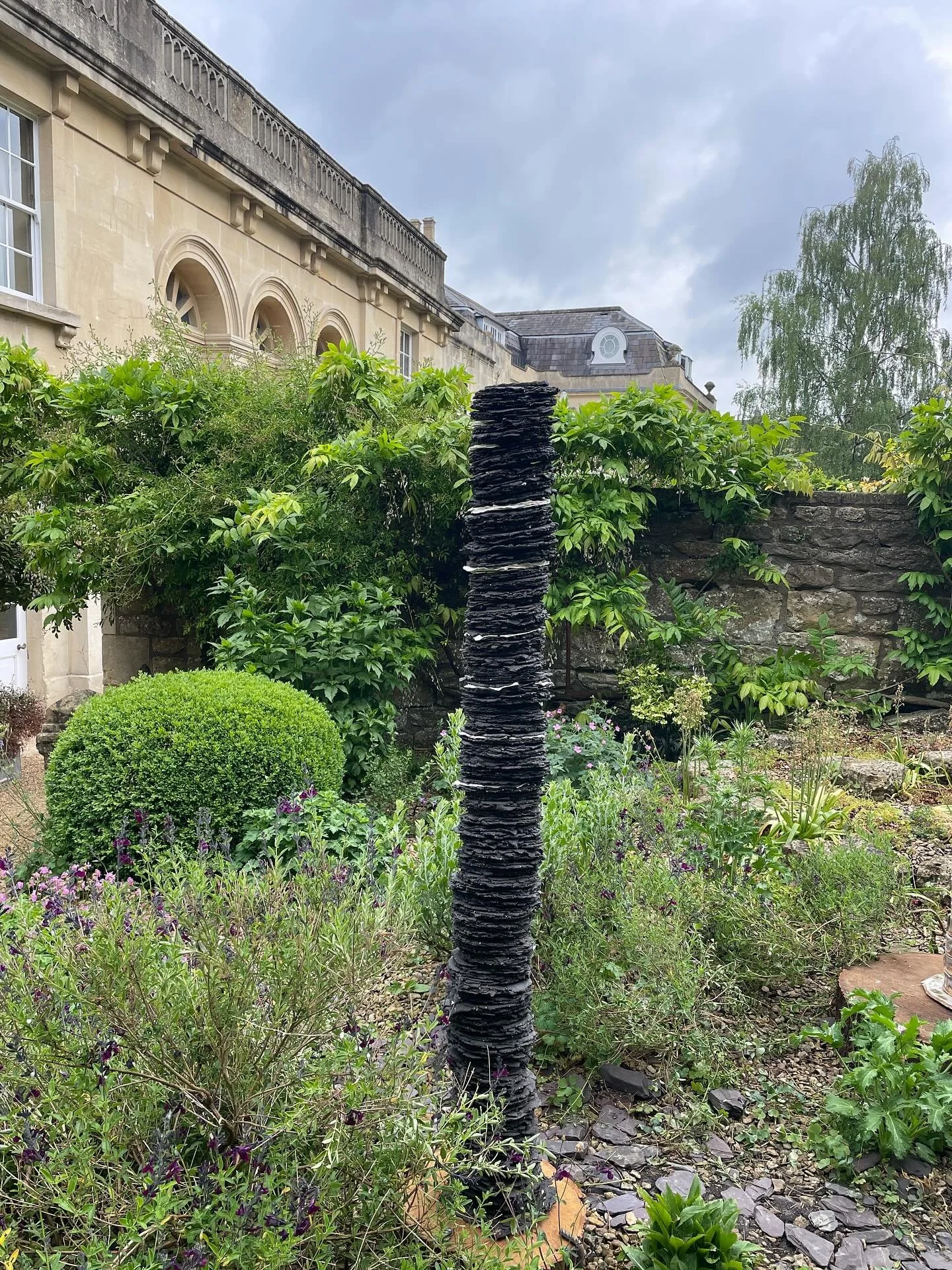 Individual ceramic stele memorialising ash trees looking at home in @royalcrescent_hotel garden as part of the sculpture exhibition by @axlearts @somerset_art_works in the gardens of The Royal Crescent Hotel in Bath with a selection of sculptures by 