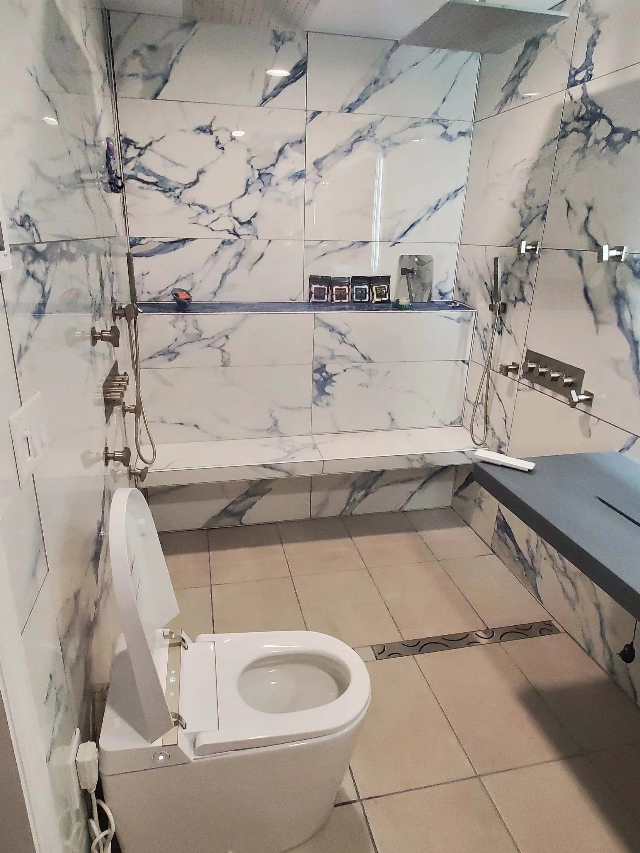 Master bathroom renovation in Chattanooga, TN showing heated tile floor, walk-in shower with heated floor, heated shower bench, floating concrete sink, tile walls, body spray and rainhead shower system