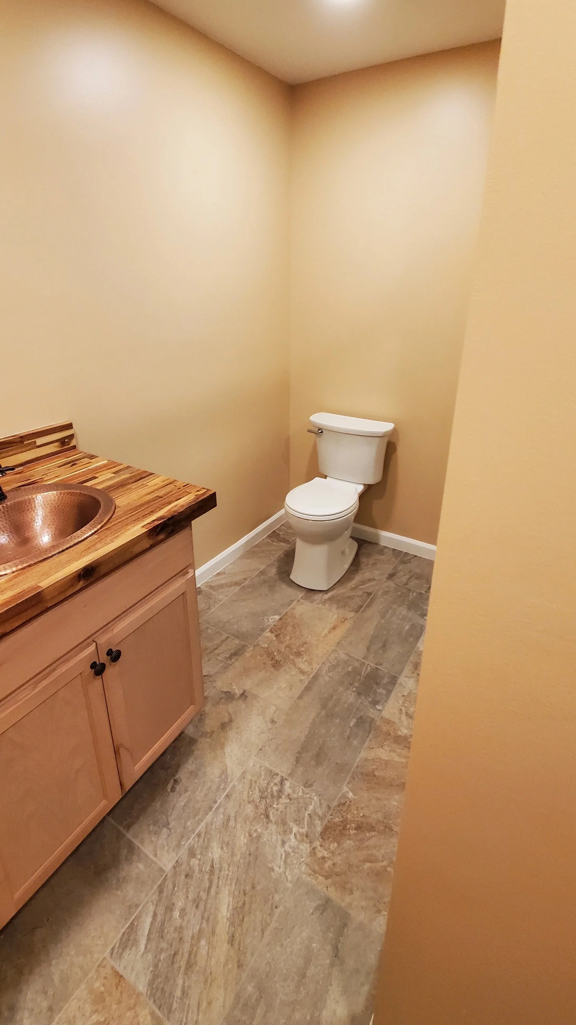 Basement bathroom in East TN showing finished vanity, toilet, tile floor, and walls