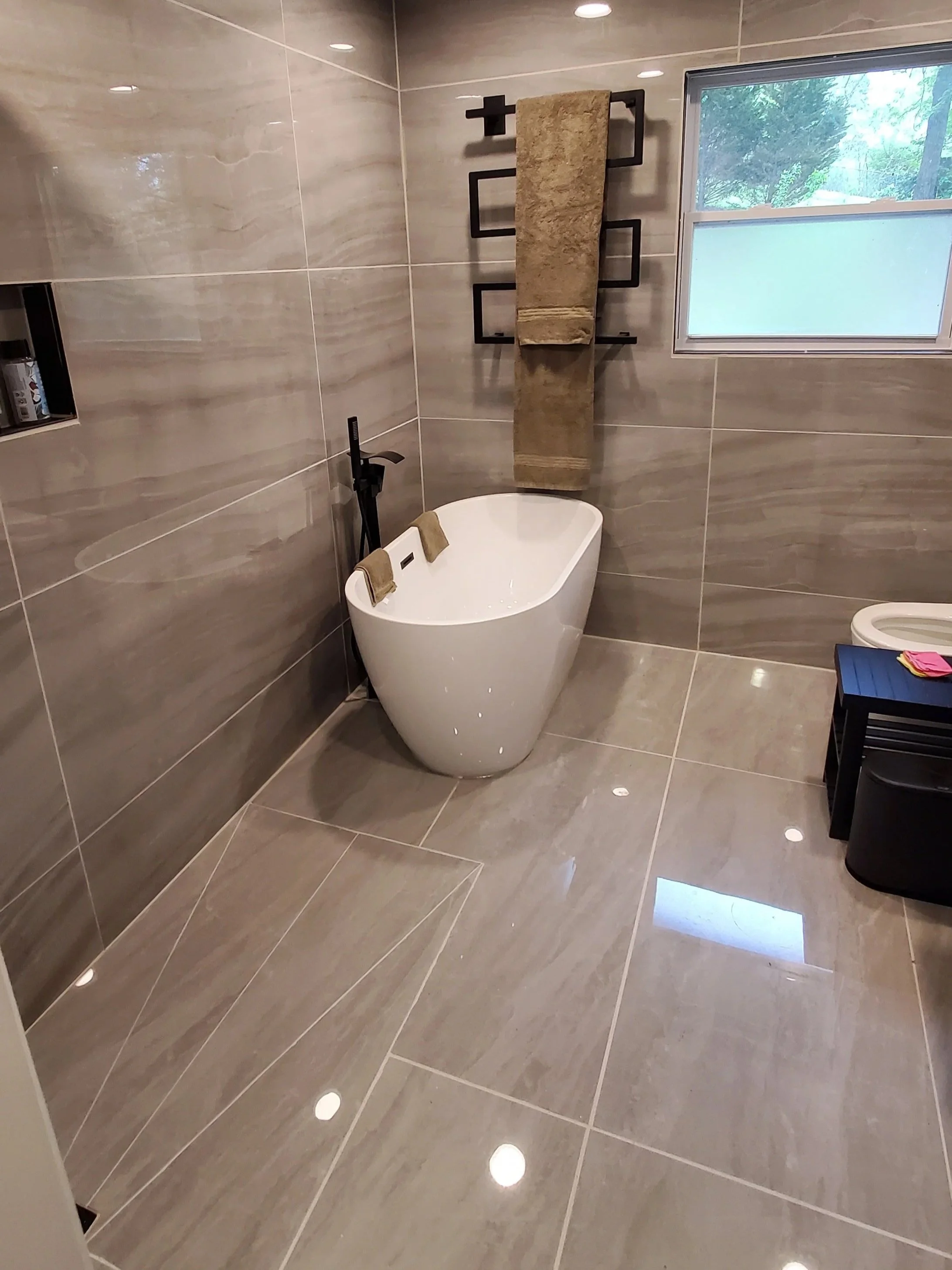 Hall bathroom remodel in Chattanooga, TN showing walk-in shower, heated tile floor, tile walls, heated towel bar, freestanding tub