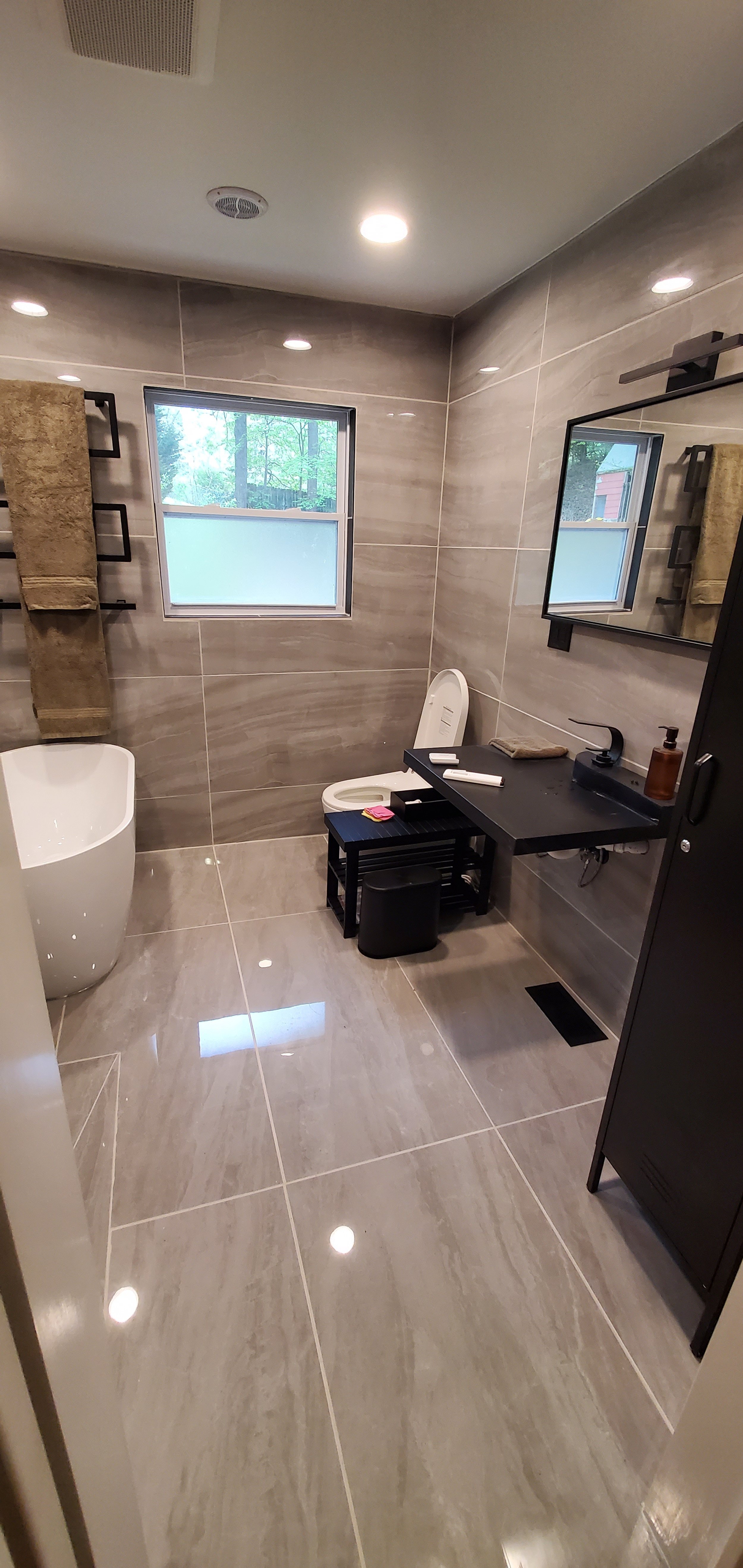Guest bathroom remodel in Chattanooga, TN, showing finished bathroom with heated floors, heated towel bar, custom concrete sink, and large format tile