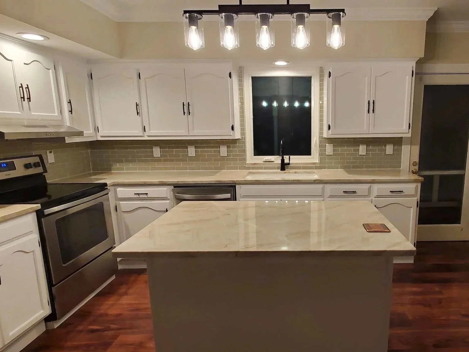Kitchen renovation in Cleveland, TN with tile backsplash, refinished cabinets, new floors, custom island