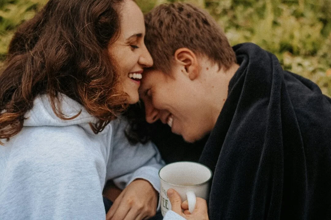 A couple leans their heads into one another, laughing EMDR to heal stuck relationship patterns