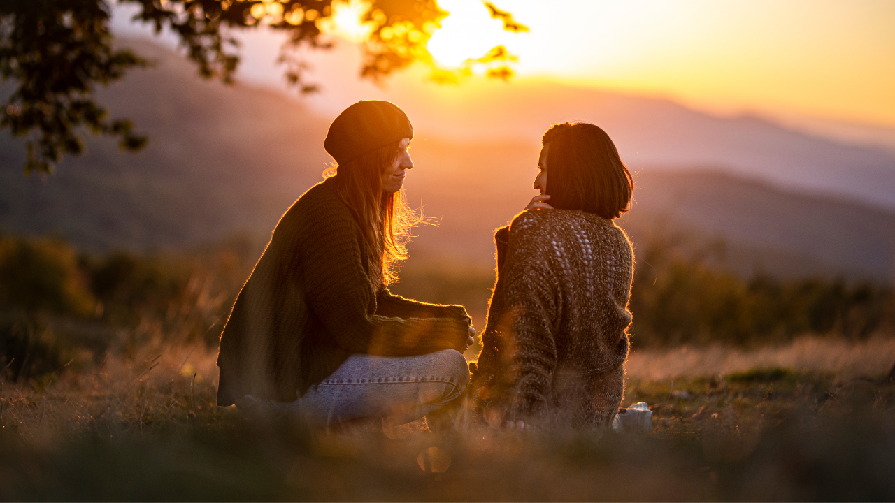 Two women in warm conversation at golden hour in the Berkshires