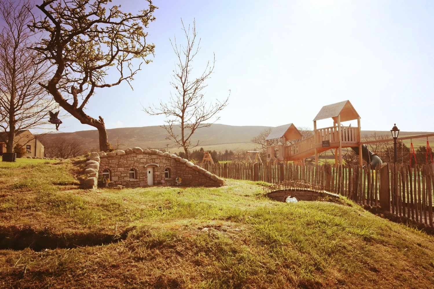 A little stone fairy house beside Fairy River's timber playpark, with the Mourne Mountains behind