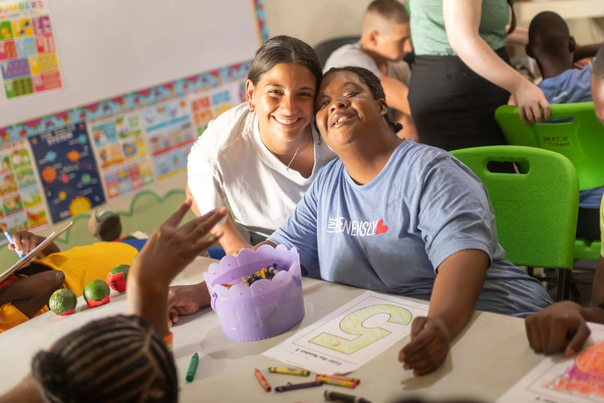 A volunteer and a West Haven resident share a hug in the classroom