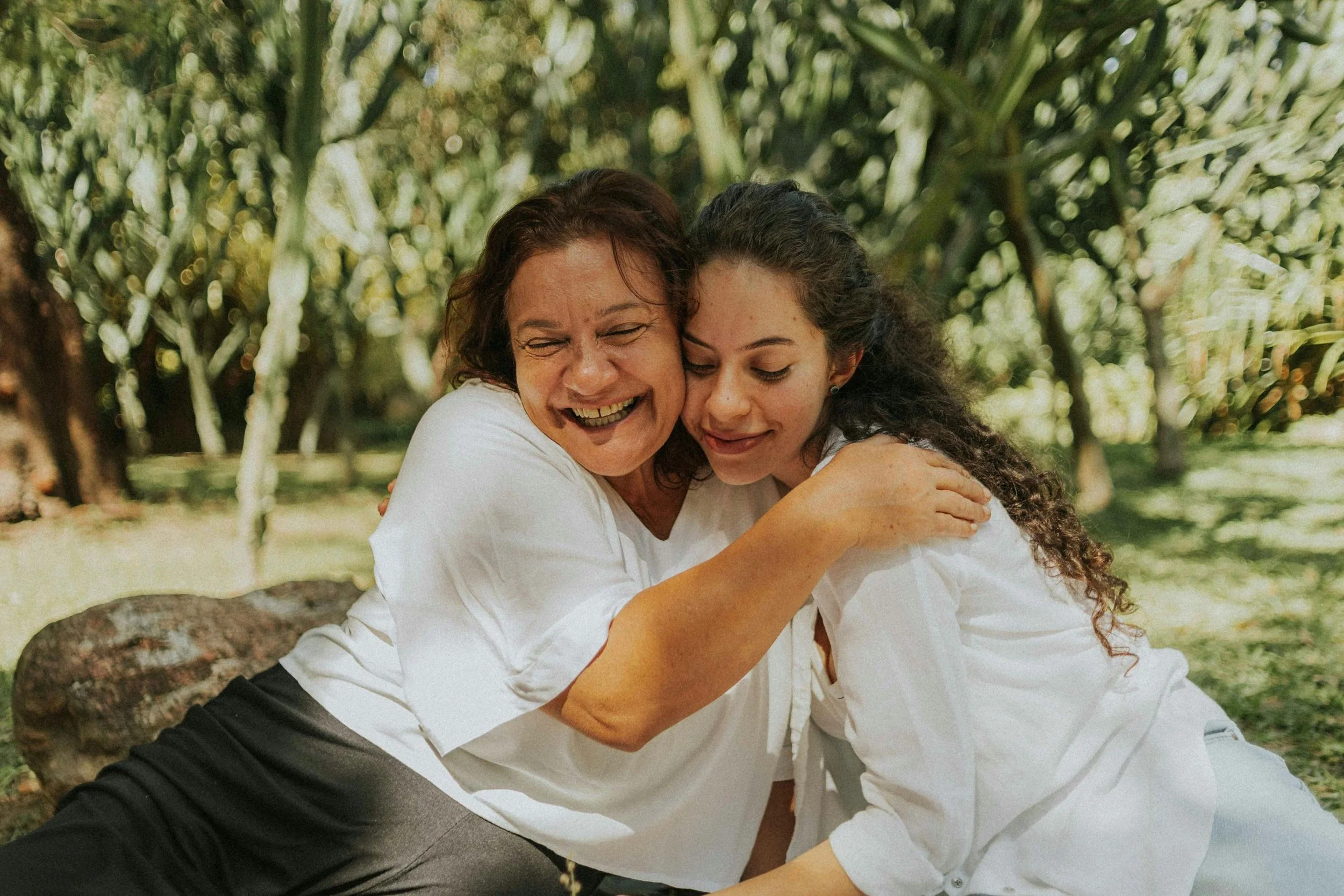 Mother and daughter hug in the shining sunlight. 