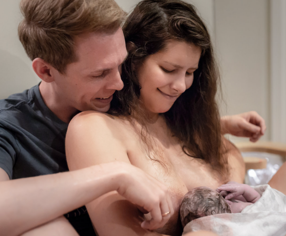 couple nursing their newborn baby together