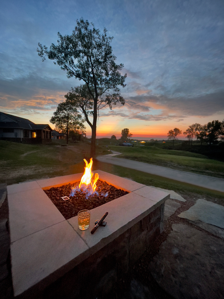    A roaring firepit overlooking the sunset at Victoria National’s golf course   