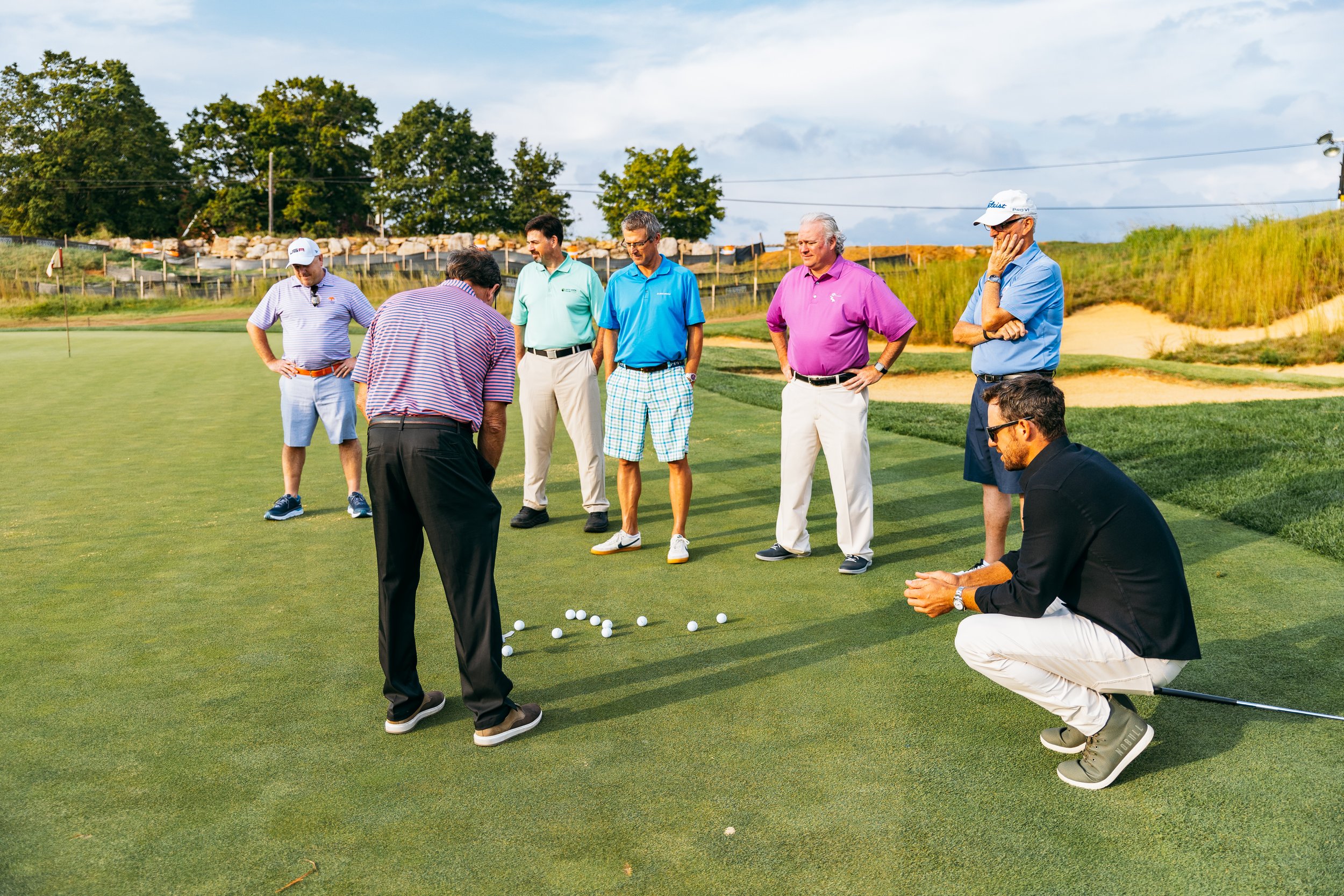 A group of golfers standing on the green.
