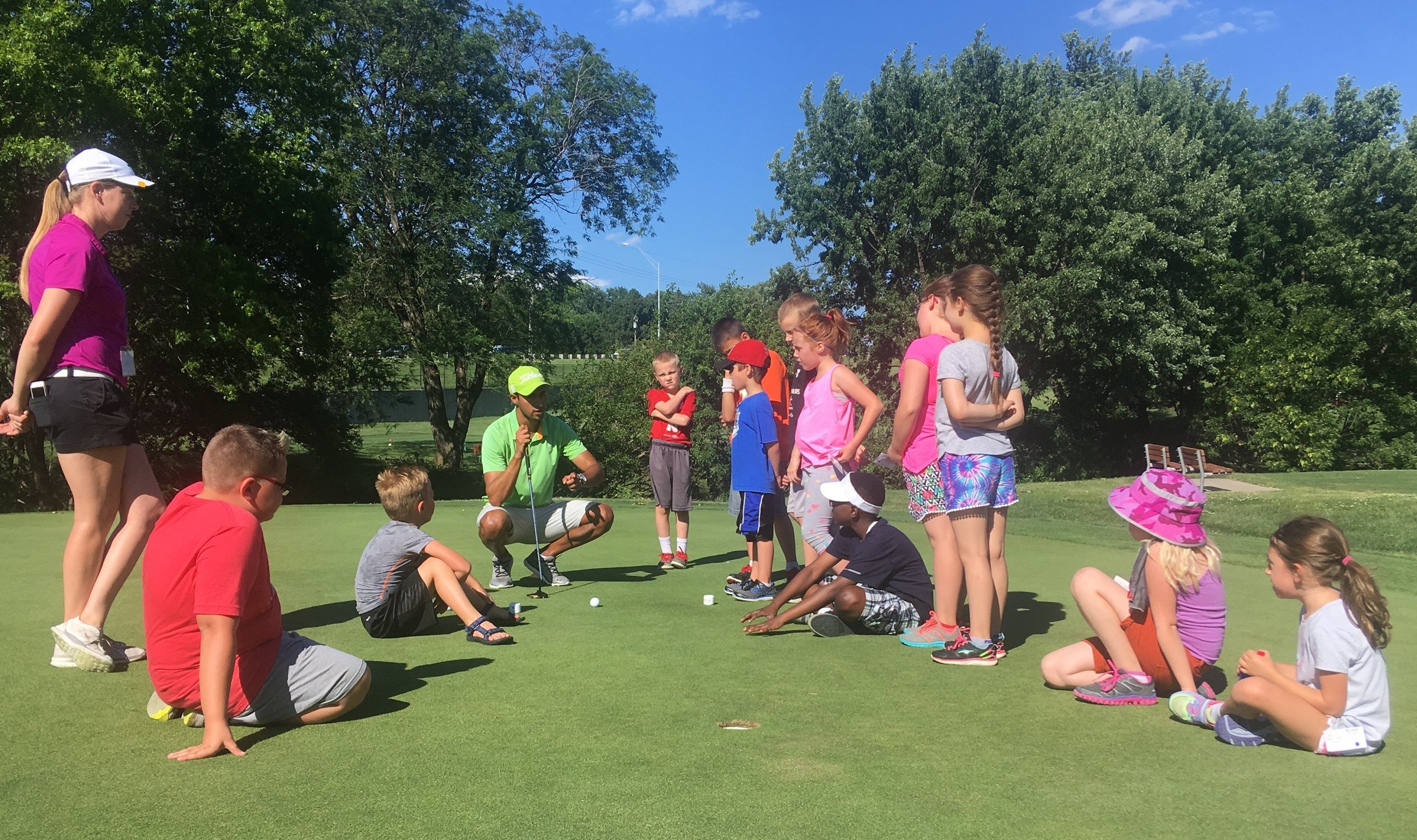 A group of young kids learning about golf.