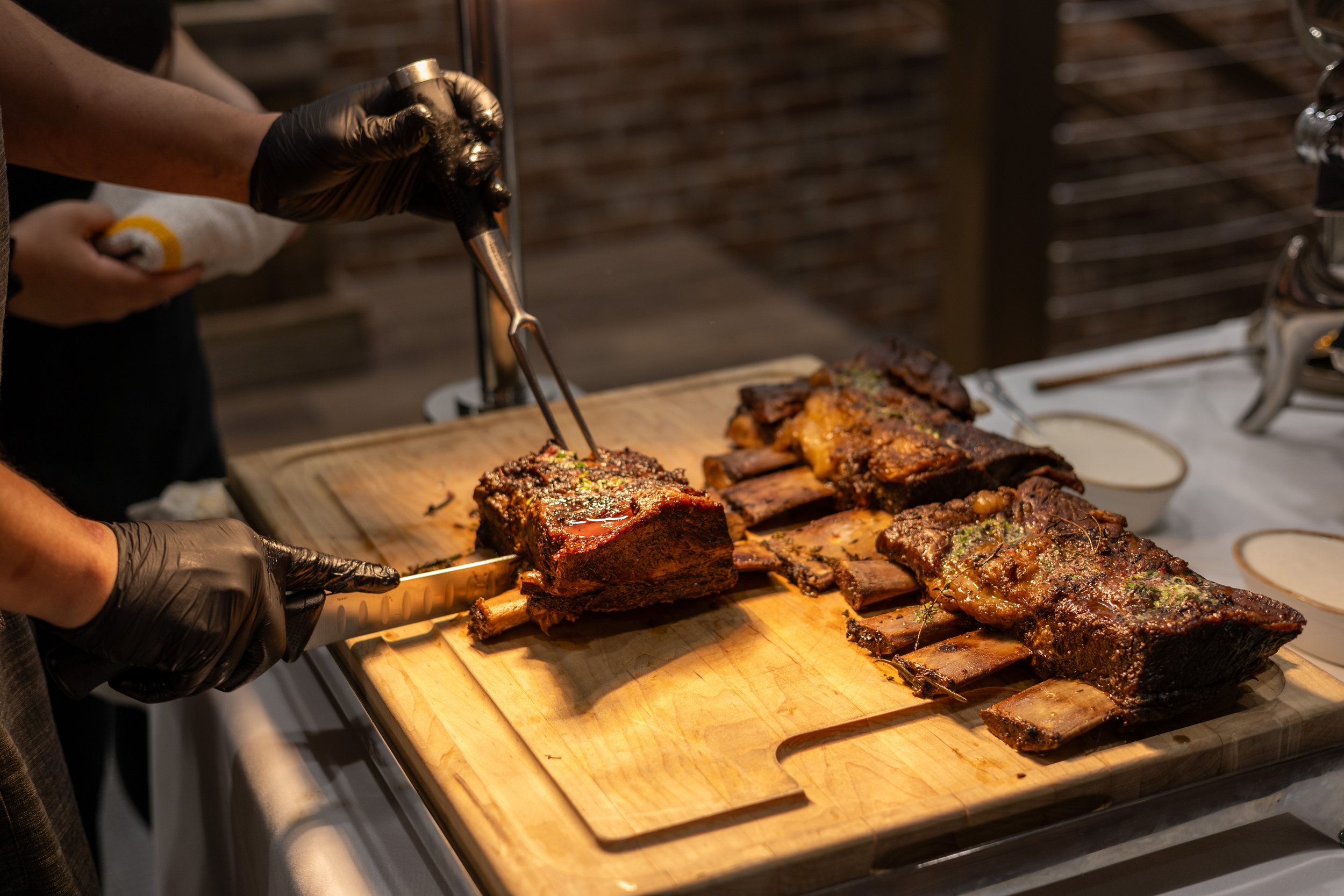 A chef cutting into a rack of lamb.