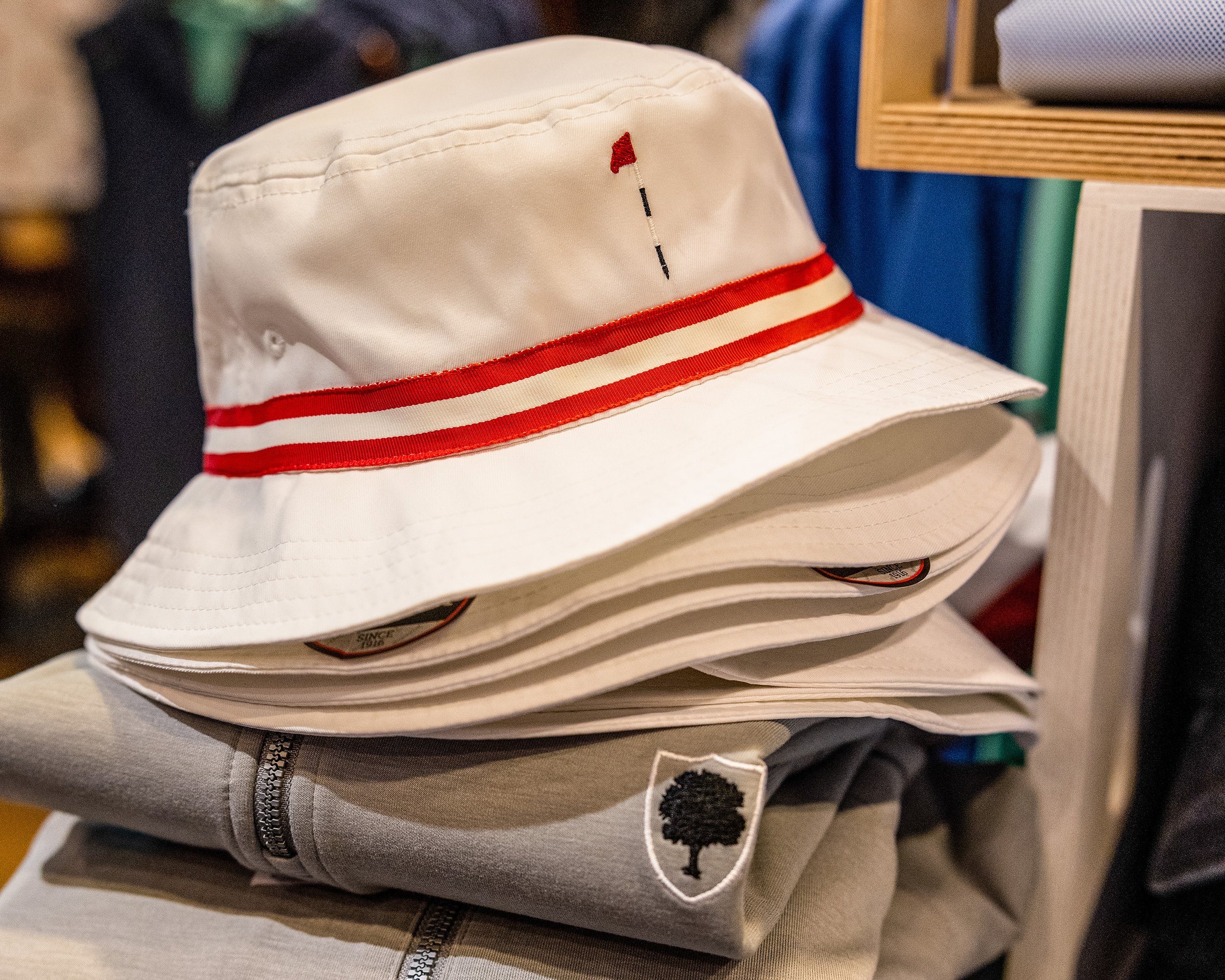 Dormie flag bucket hat on top of folded polos