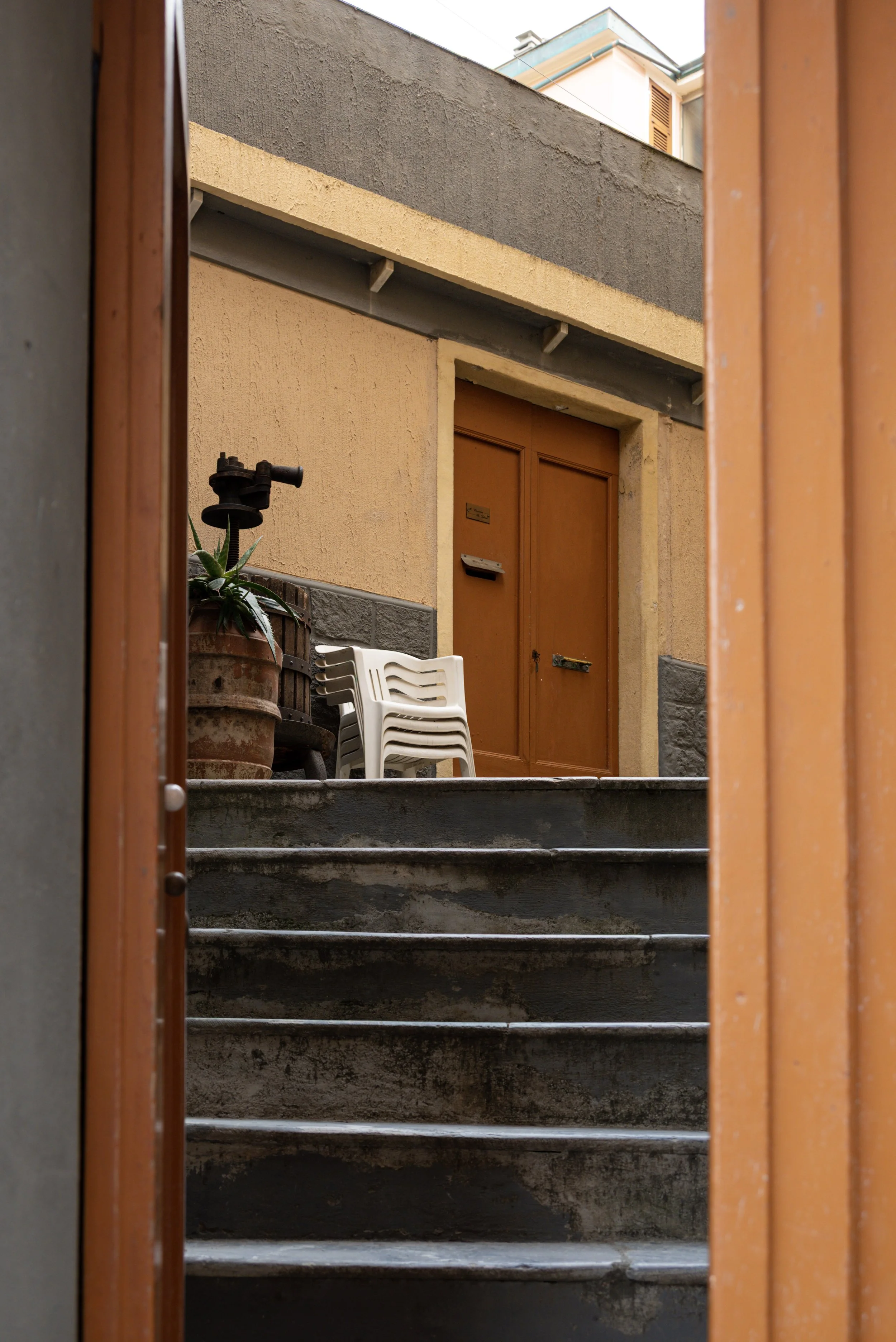 Photograph from Capri showing a staircase leading to a small terrace with a set of chairs.