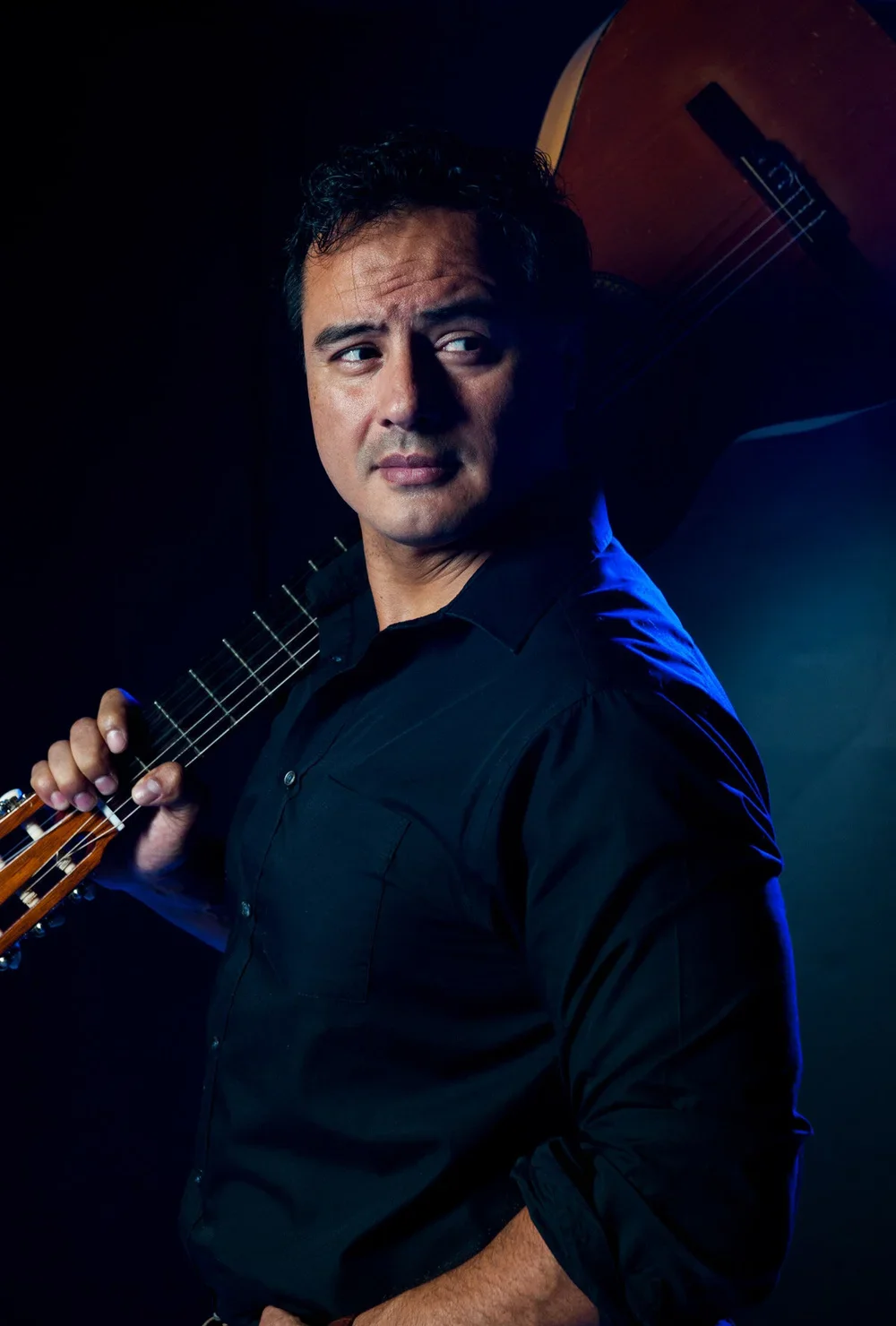 Stylized photo of Jesús Daniel Hernández holding a guitar.