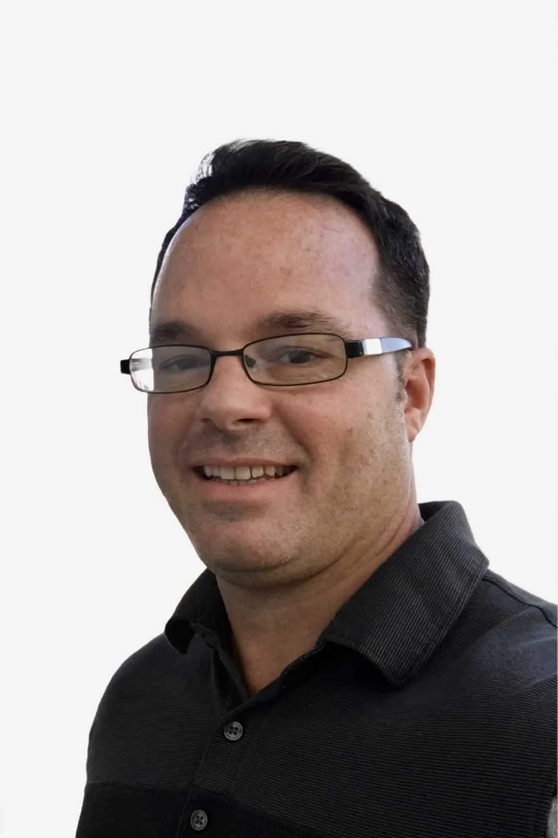 A man wearing glasses and a black shirt, smiling, against a plain white background.