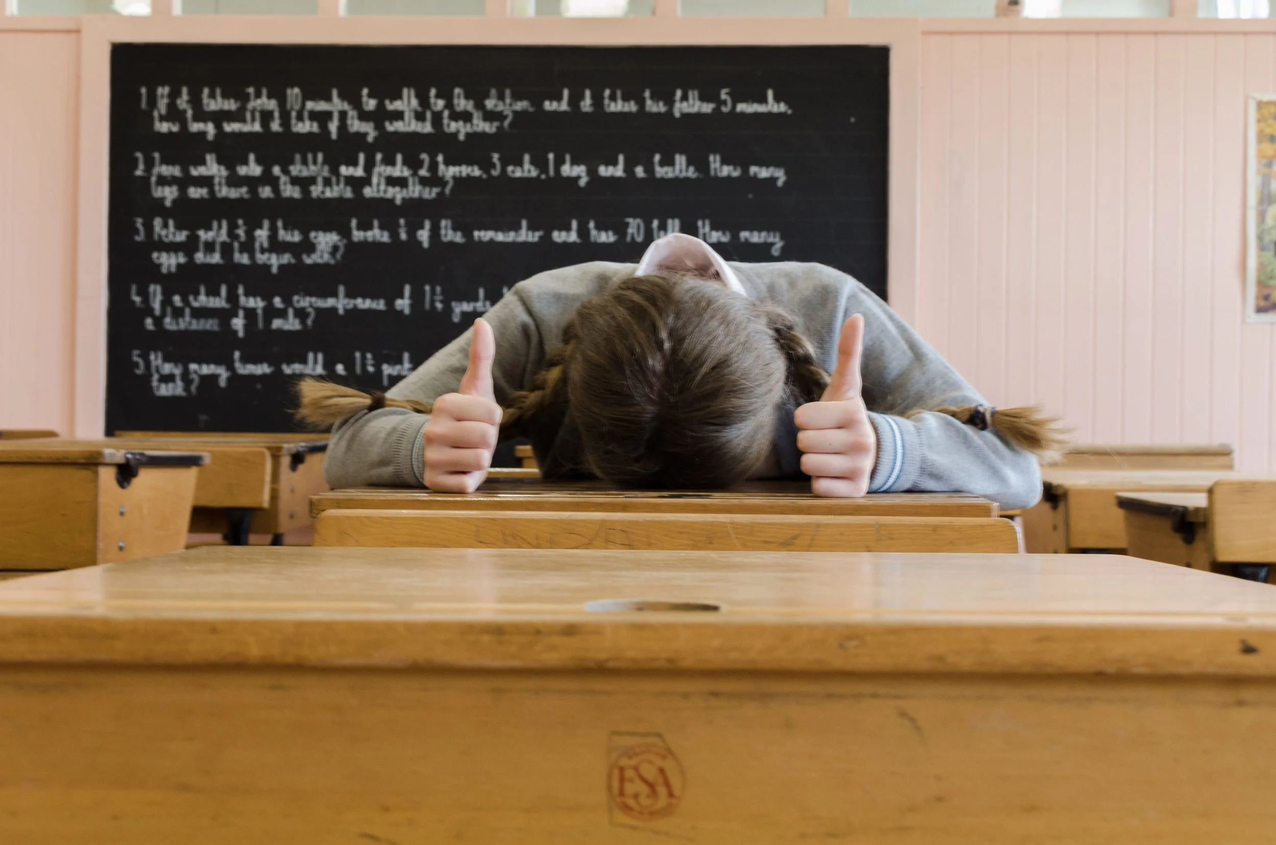 teen in classroom with head on desk