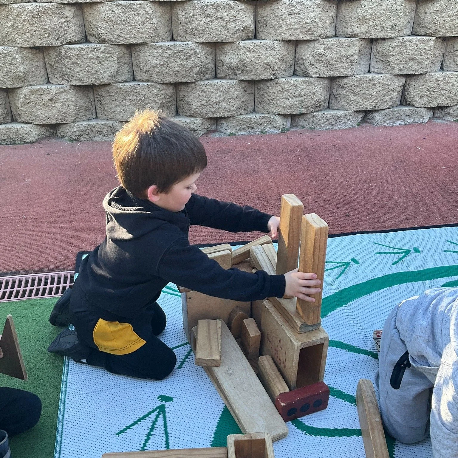 The block area moved outdoors and we wasted no time, turning the open space into a world of towers, bridges and pathways. Working side by side, we lifted, balanced and experimented, each idea sparking another.

Through this play, we developed importa