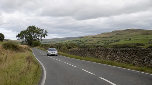 Car driving on the left-hand side of a rural UK road