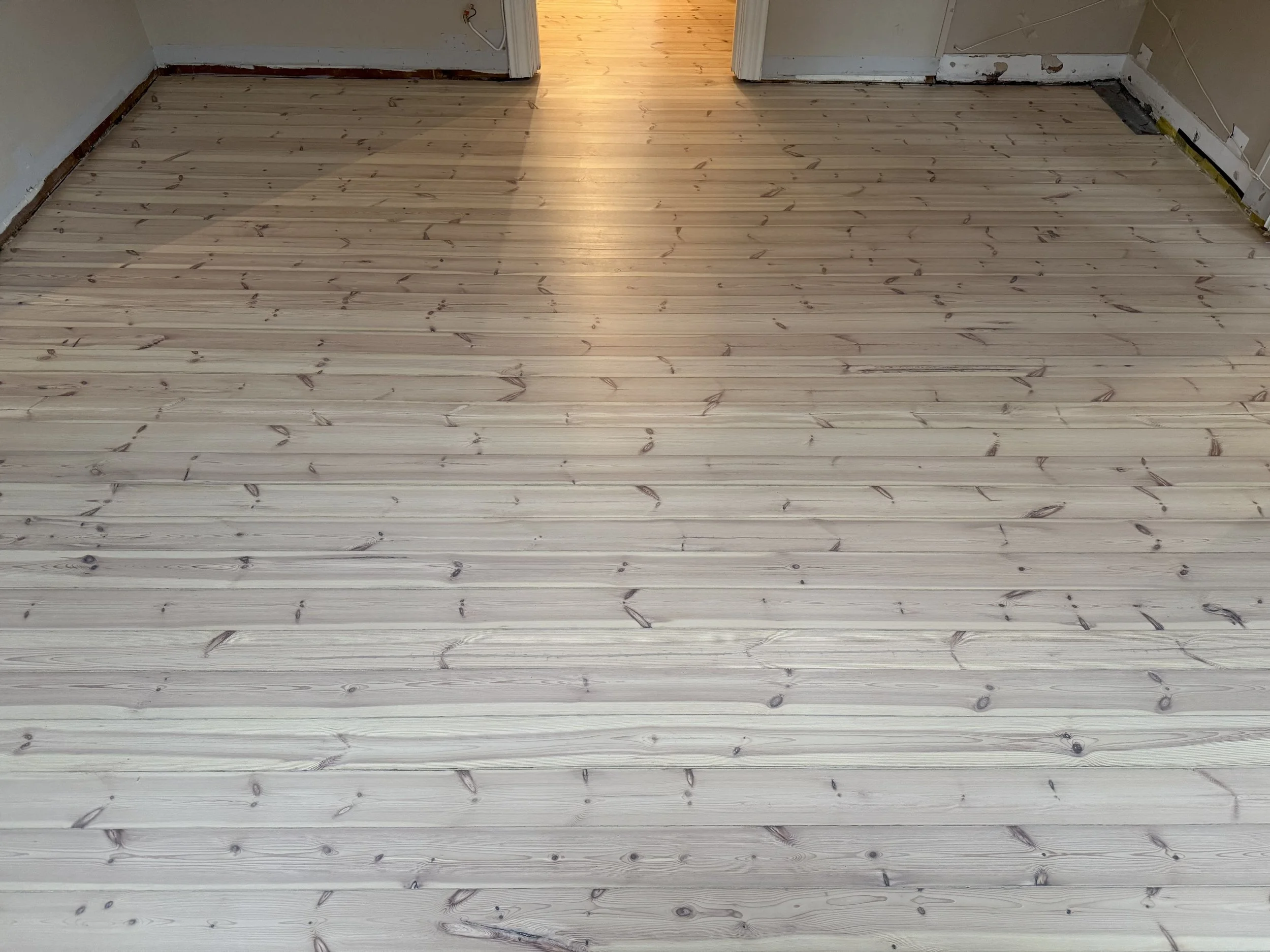 furugulv som er slipt, tettet sprekker, hvitpigmentert og lakkert