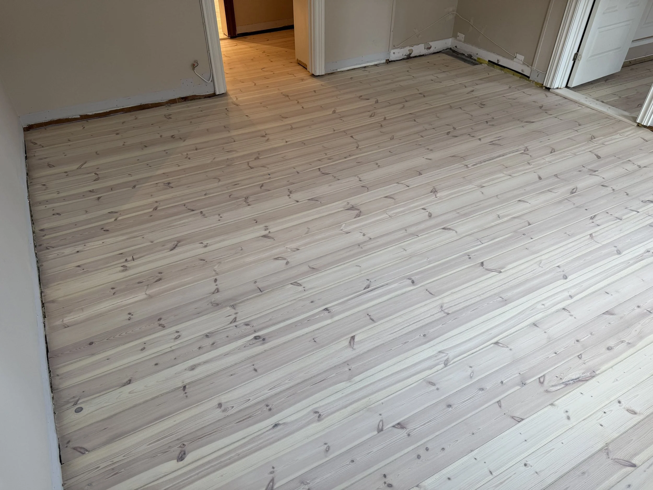 furugulv som er slipt, tettet sprekker, hvitpigmentert og lakkert