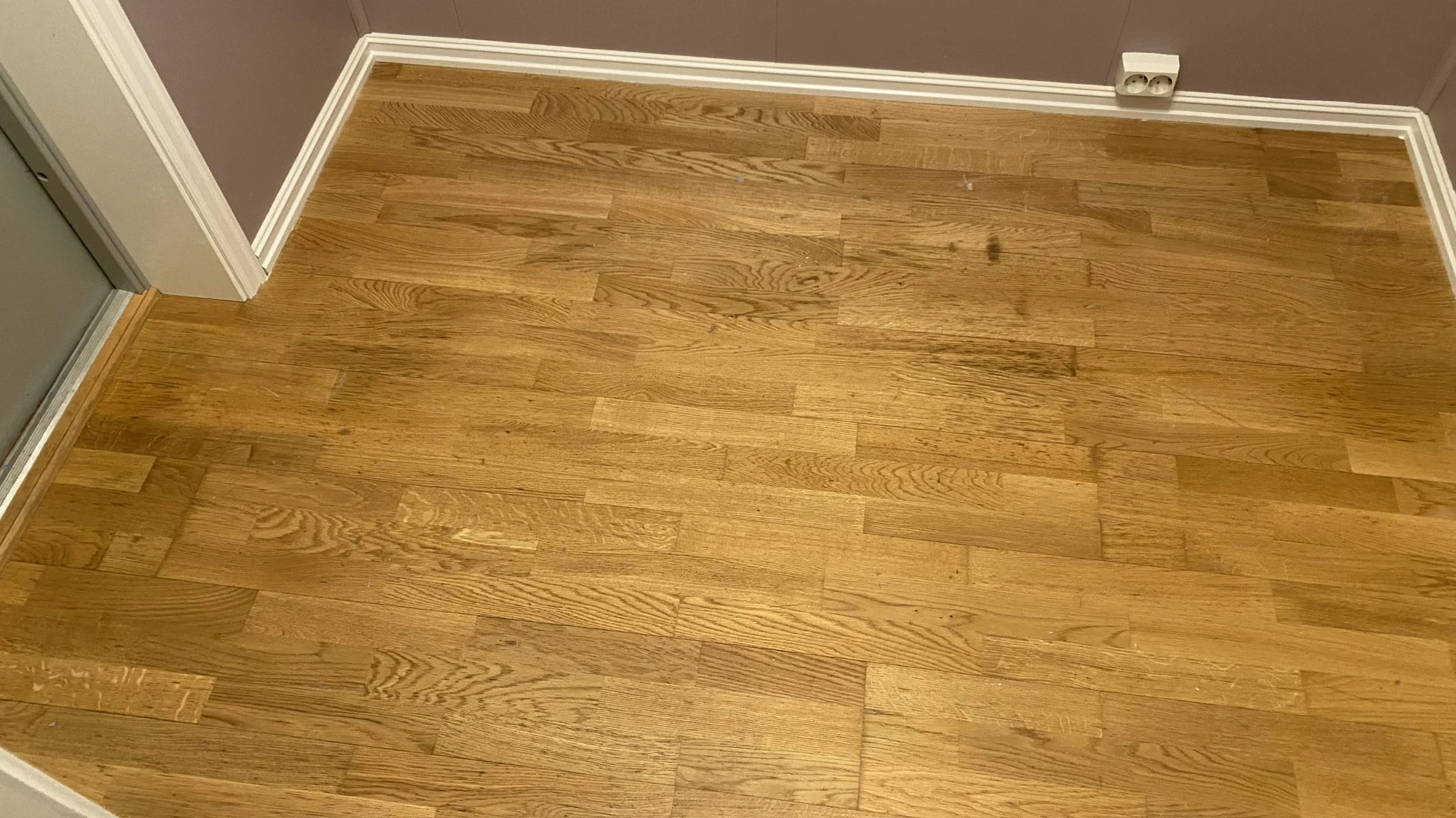 Gulnet og slitt trestavsparkett før gulvsliping i leilighet i Oslo