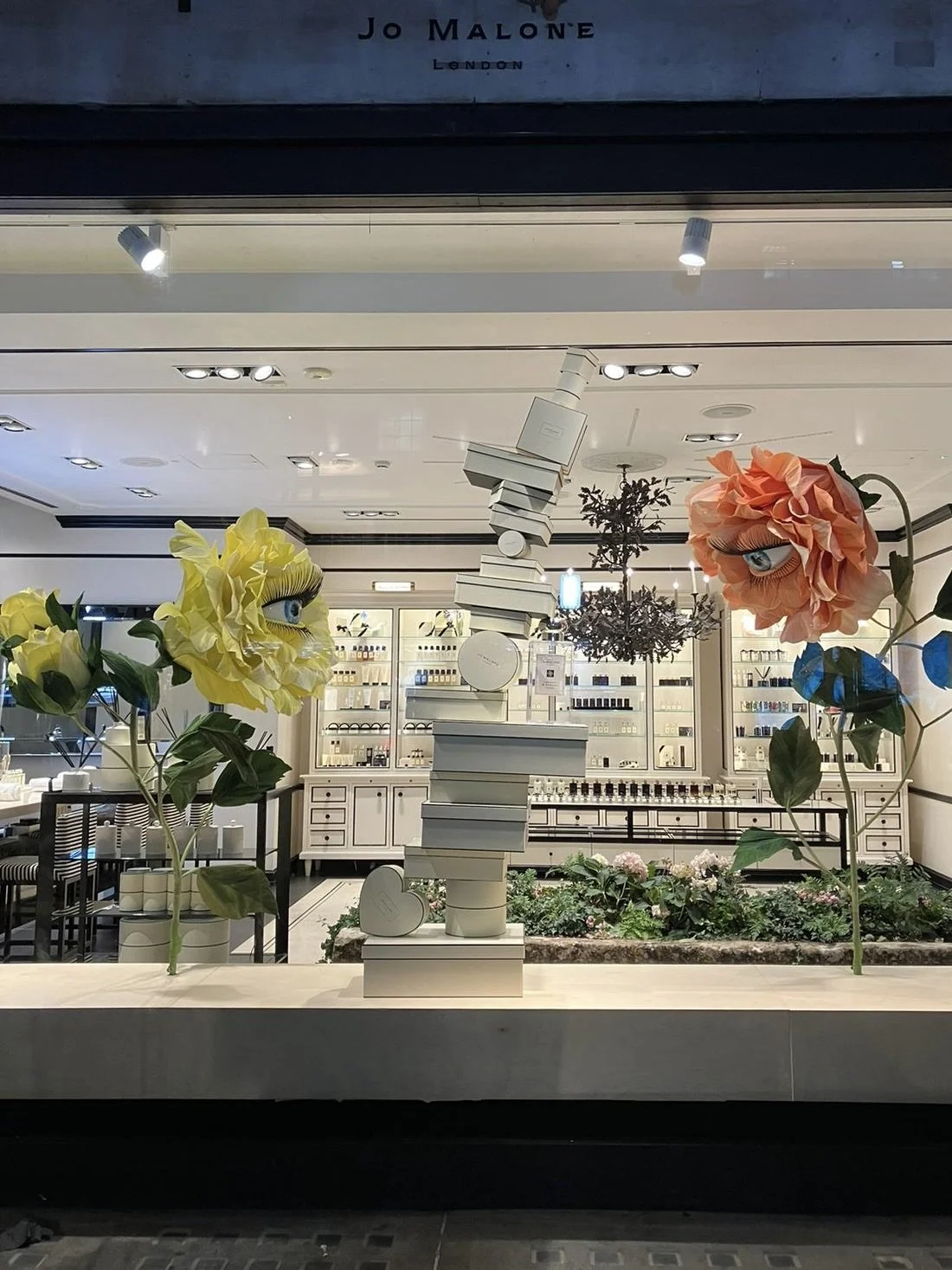 Jo Malone London window display featuring giant paper roses with animatronic eye which blinks. Flowers made by Fiona Coupe Studio for window display