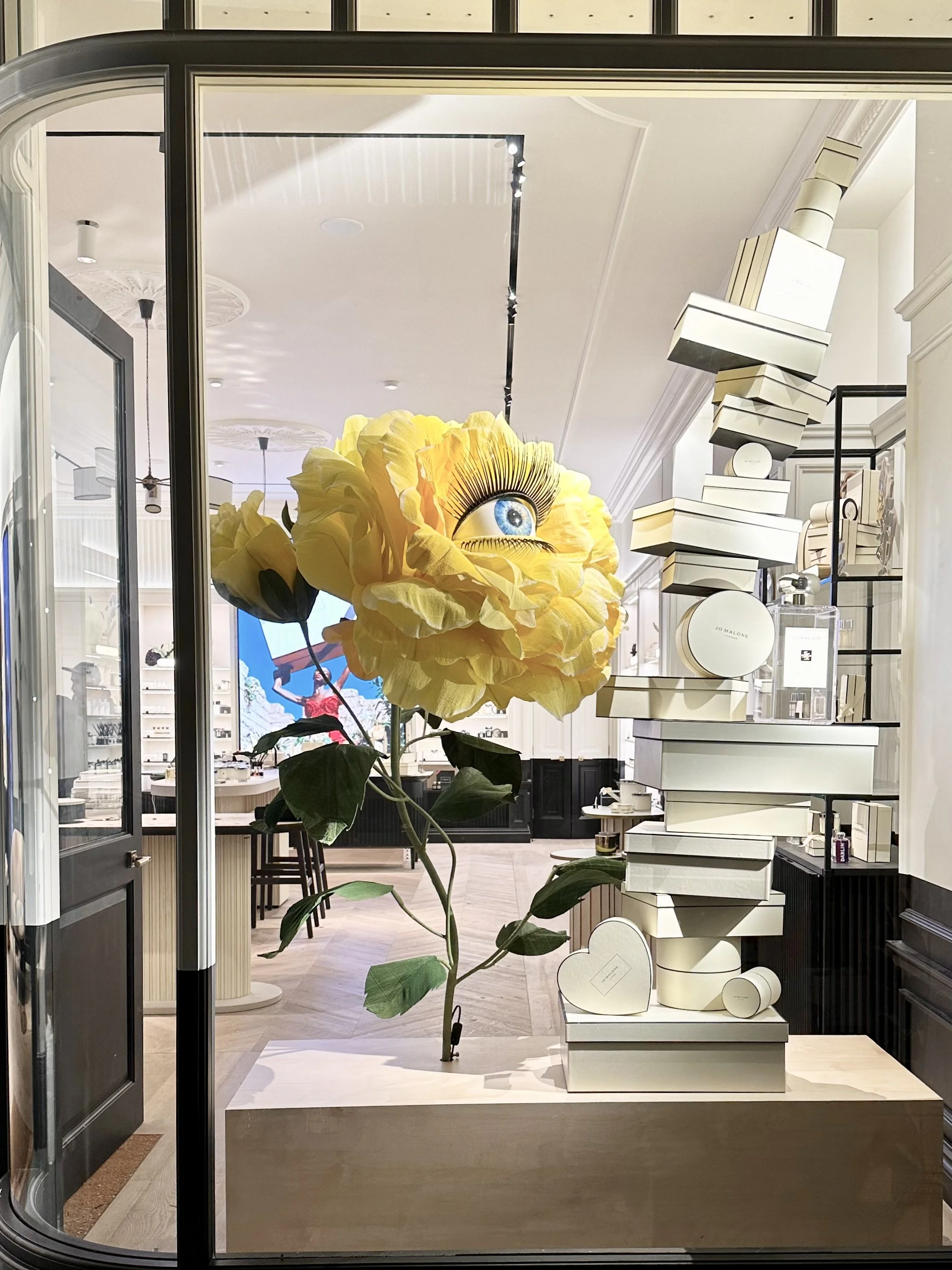 Giant yellow rose with blinking eye in center in Jo Malone London window display in Covent Garden