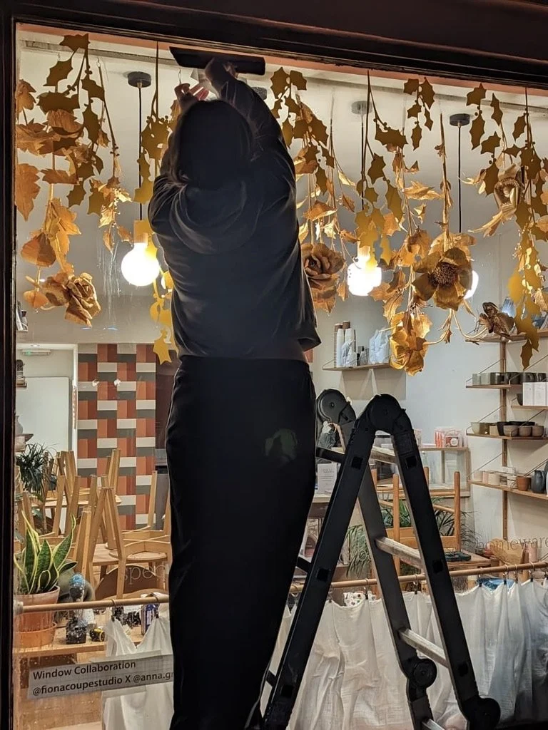 Gold crepe paper flowers for a christmas window display at Loam Coffee Shop in Brighton