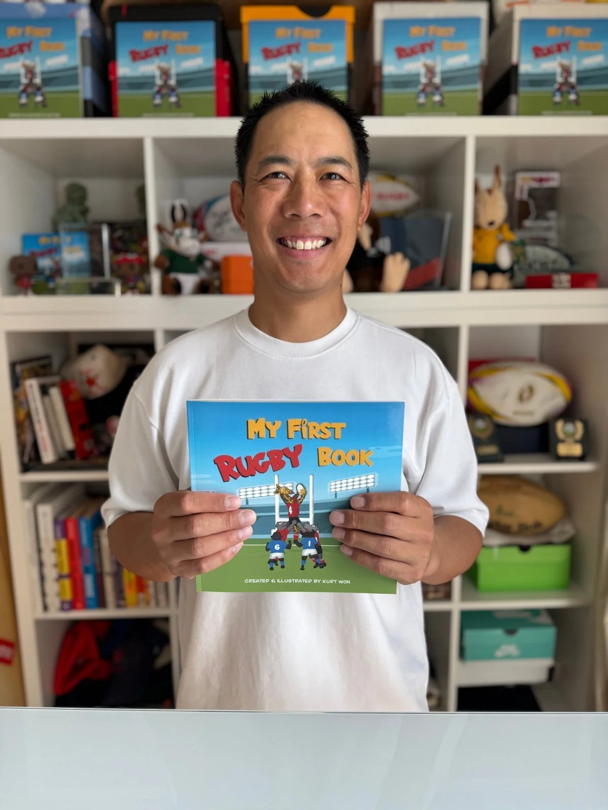Kurt Won, author and illustrator, holding My First Rugby Book